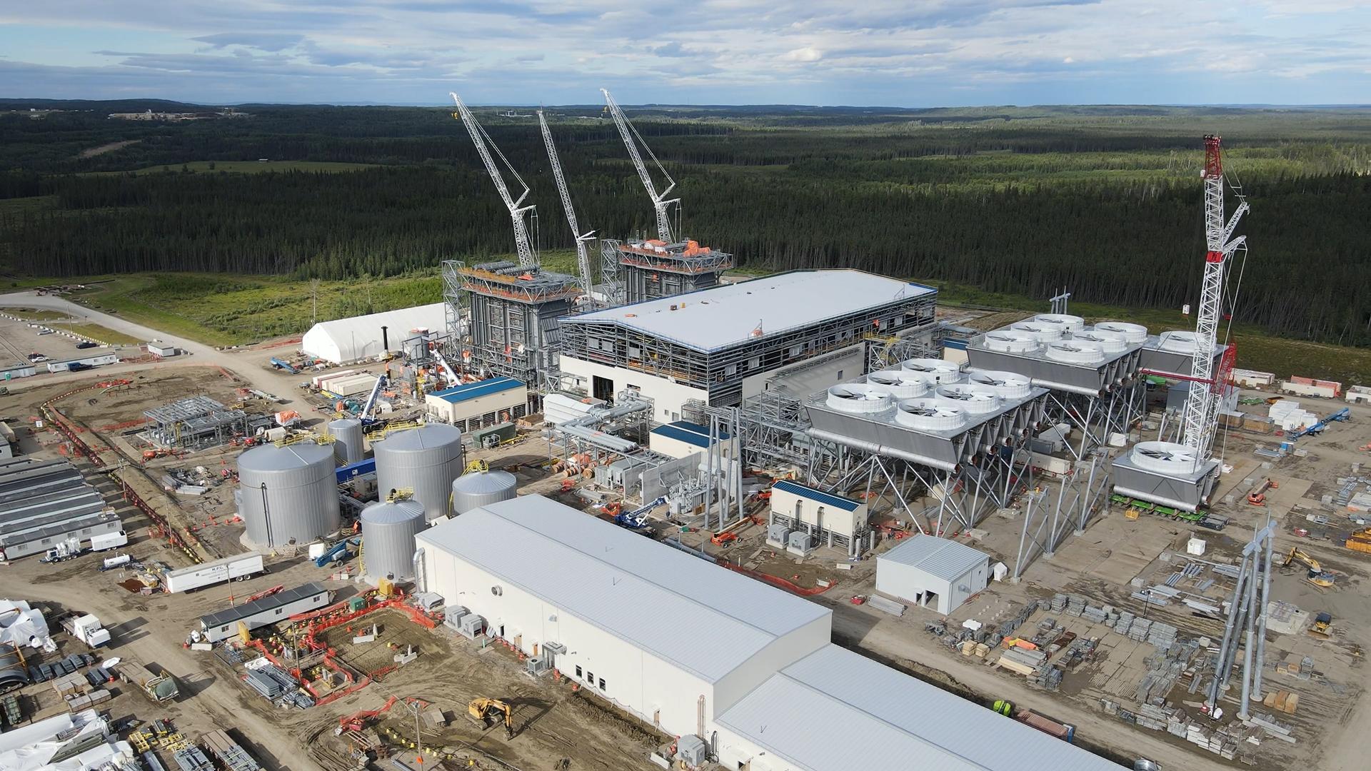 Aerial of Cascade power plant construction with trees and forest in background