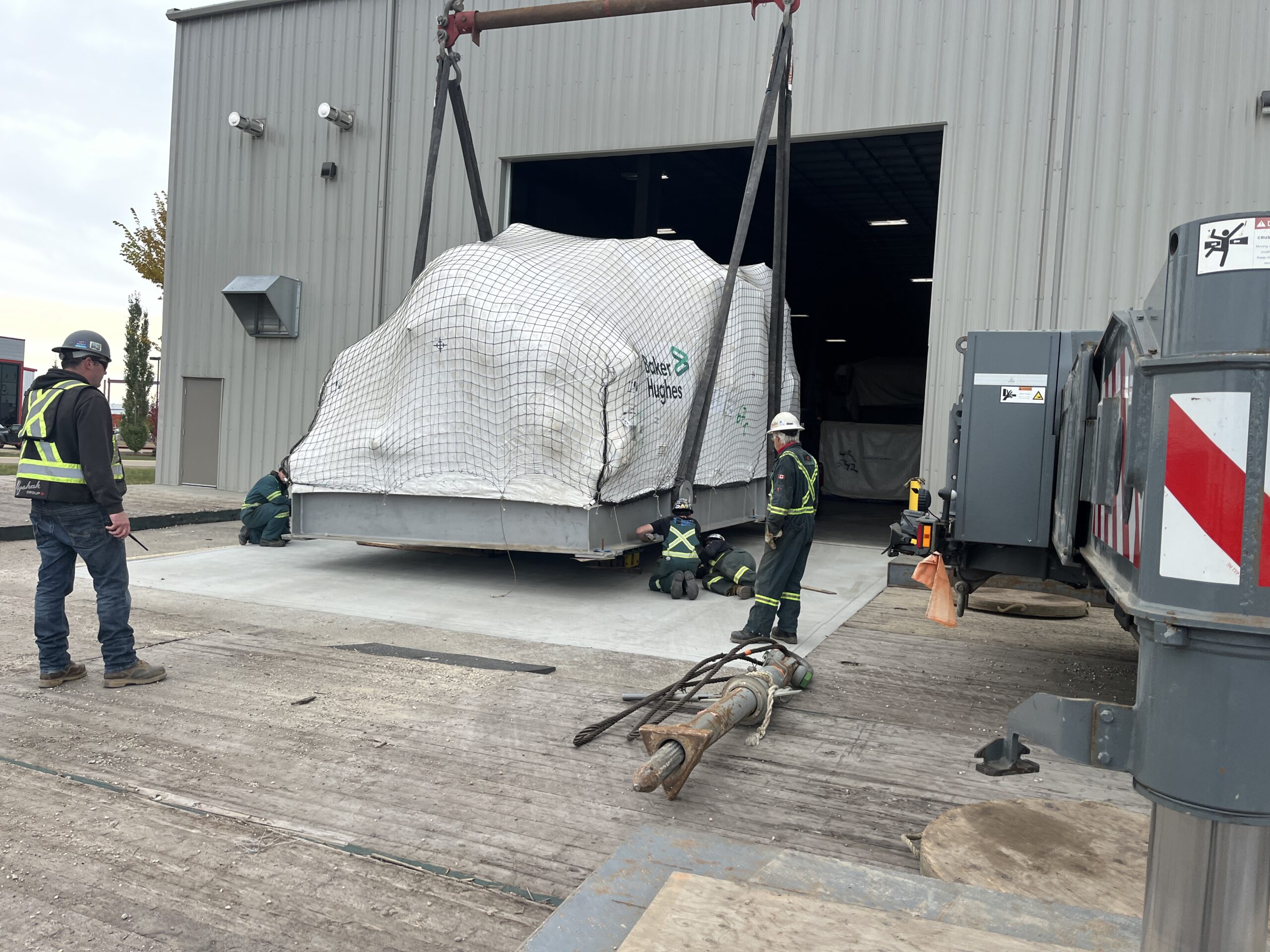 Myshak team lifting some heavy equipment into the warehouse loading bay