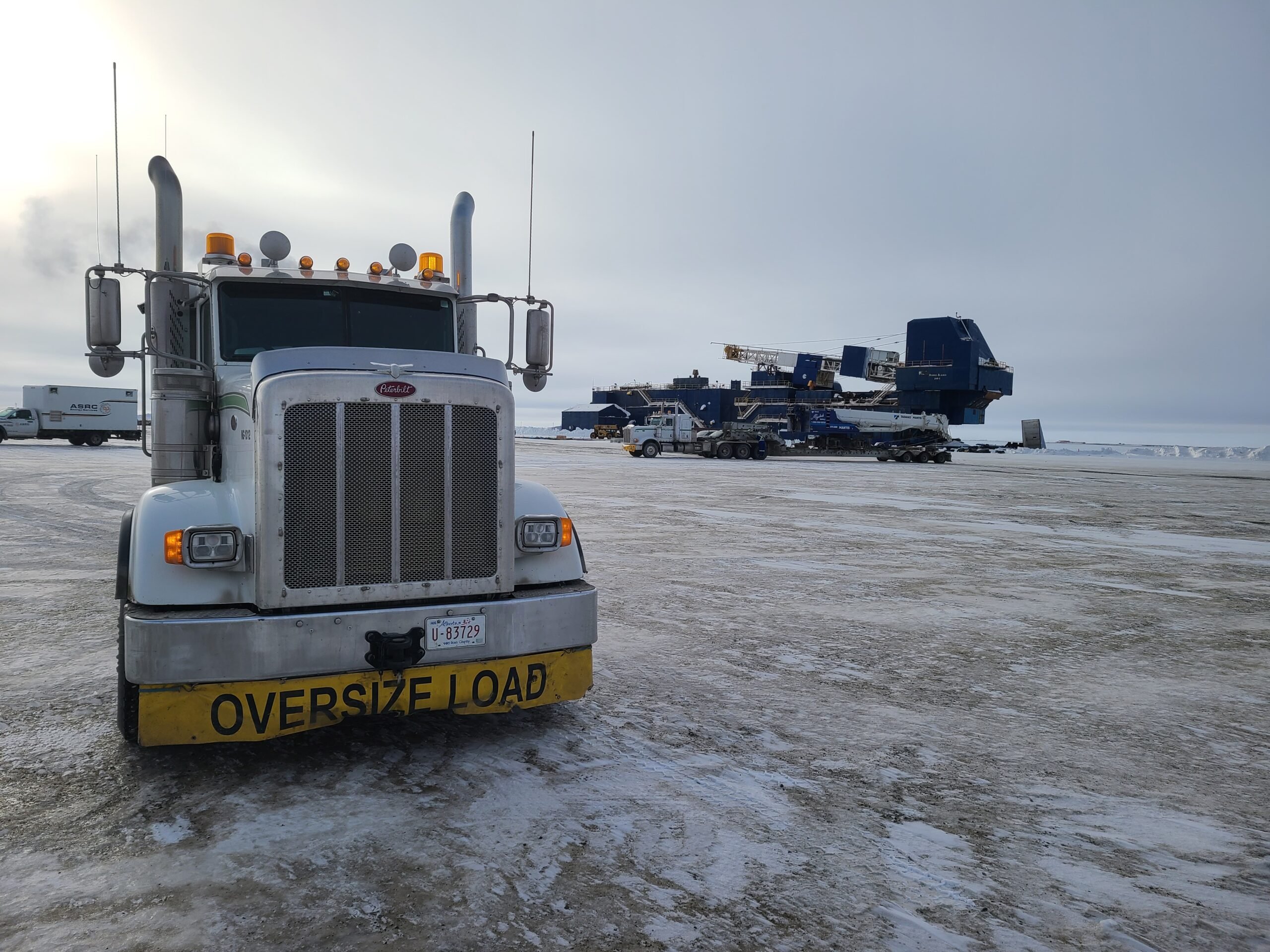 Front of a Myshak semi-truck and a large rig move in background.