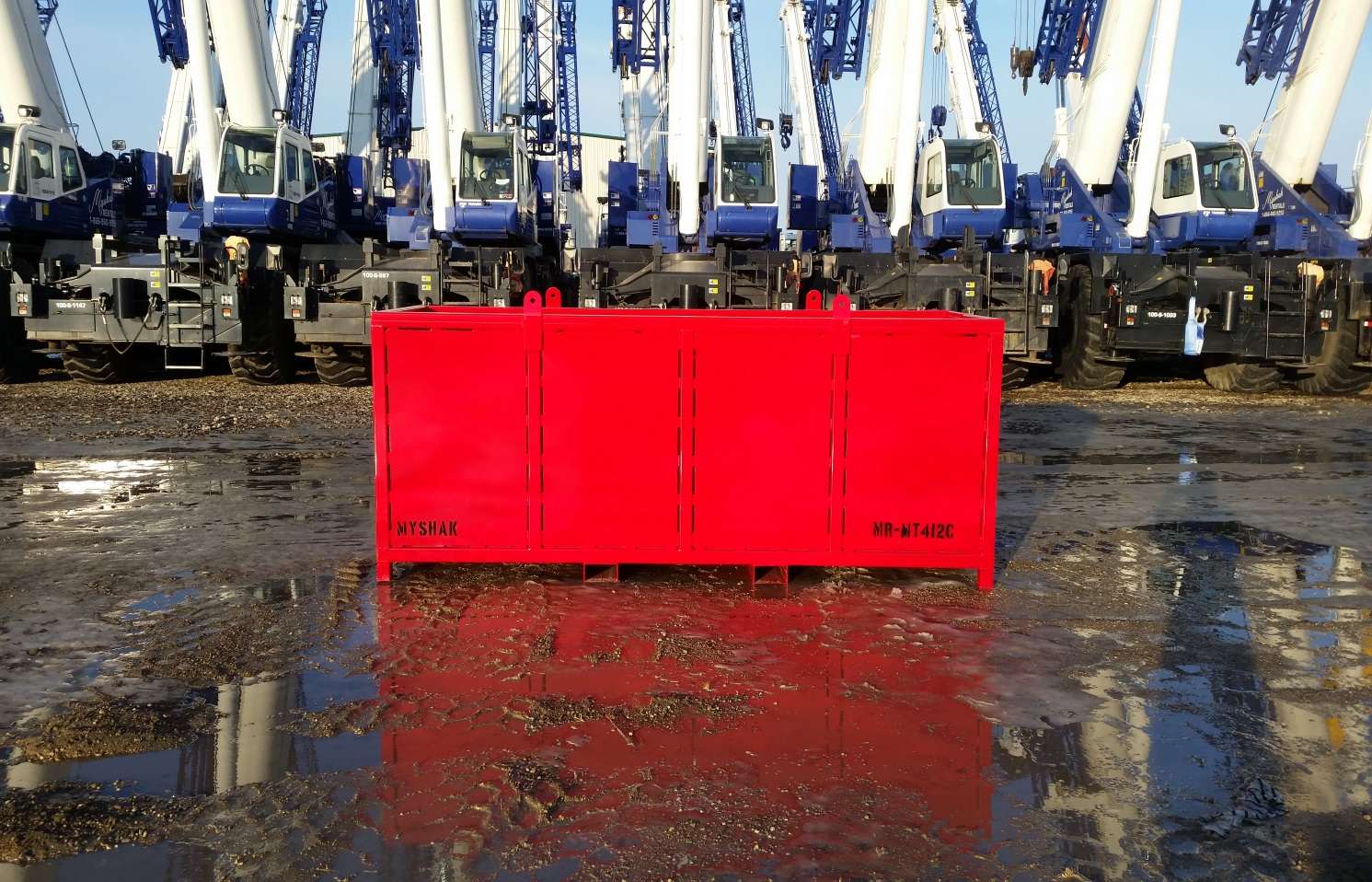 Large red material basket with cranes in background